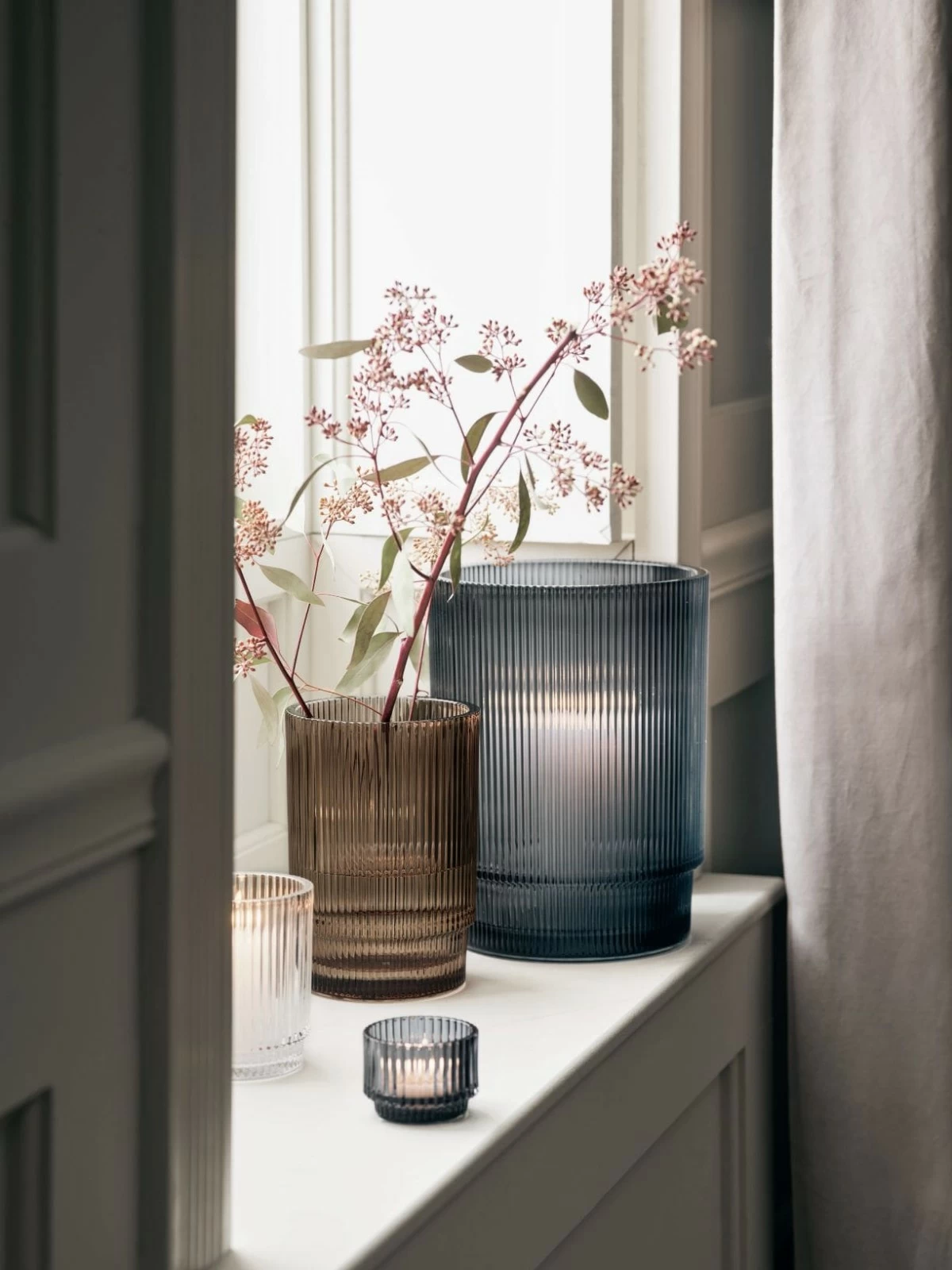 Inspired by our exclusive Atwell drinkware, this candlelight collection is a modern take on classic glass hurricanes. Sparkling tiers of ribbed glass shape a tealight holder and hurricanes in various hues. The ridged surface catches the light while filtering candlelight to create a moody, ethereal glow.
