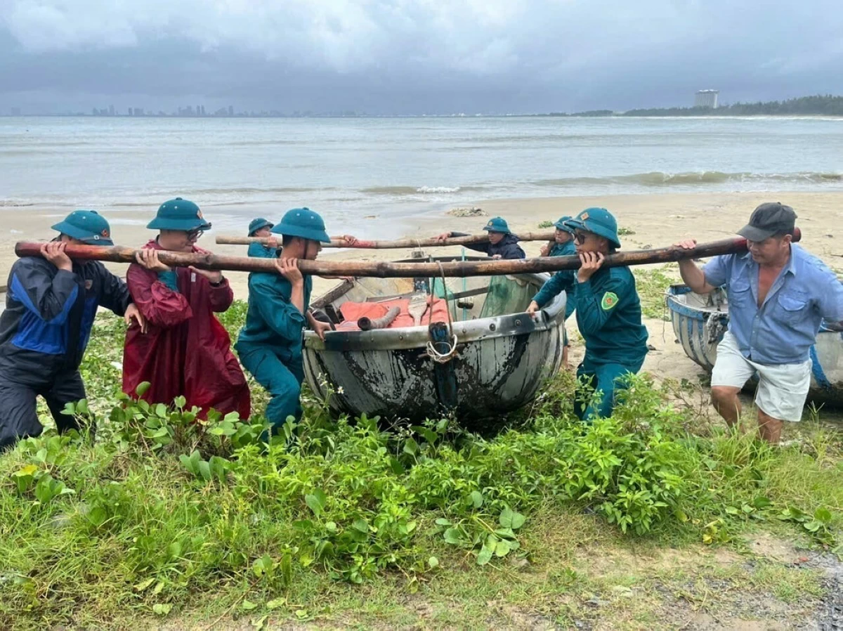People move a fishing boat from the beach ahead of Typhoon Bualoi in Danang, Vietnam Sunday, Sept. 28, 2025. (Trinh Quoc Dung/VNA via AP)