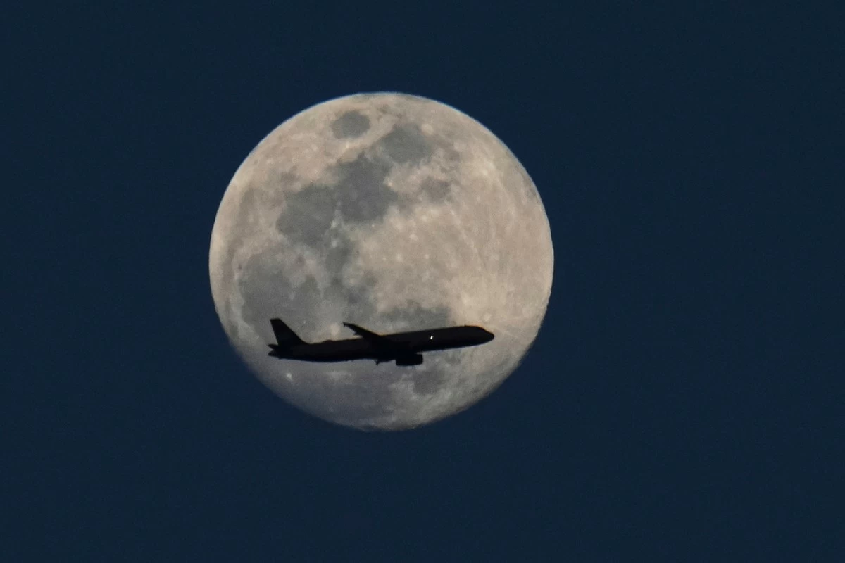 FILE - A waxing gibbous moon is seen as a plane flies by March 12, 2025, in Grand Prairie, Texas. (AP Photo/Julio Cortez, File)