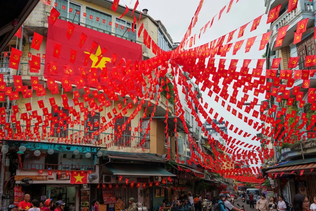 FILE -Vietnamese and communist flags hang from balconies across streets in the old quarter of Hanoi, Vietnam, Sept. 1, 2025. (AP Photo/Vincent Thian, File)