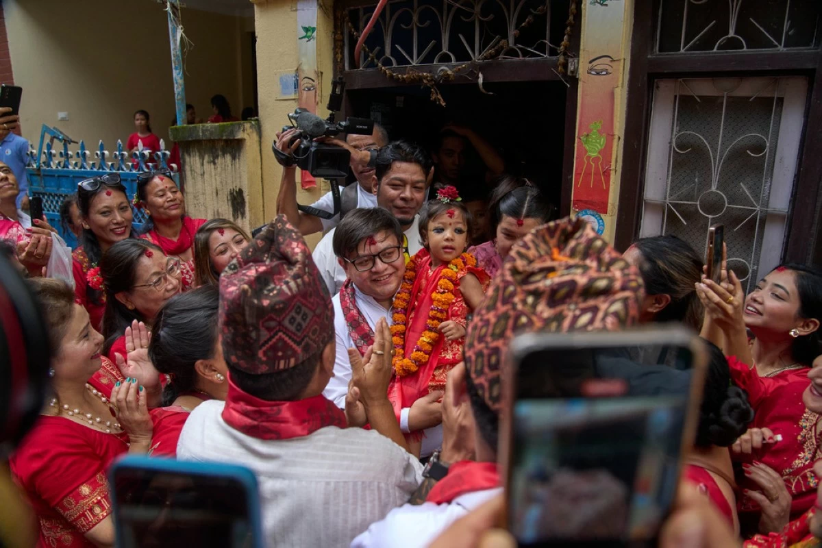 Nepal's newly appointed living goddess, Kumari Aryatara Shakya, is carried by her family member as they get ready to walk towards Kumari Ghar, the temple palace where she will be residing in Kathmandu, Nepal, Tuesday, Sept. 30, 2025. (AP Photo/Niranjan Shrestha)