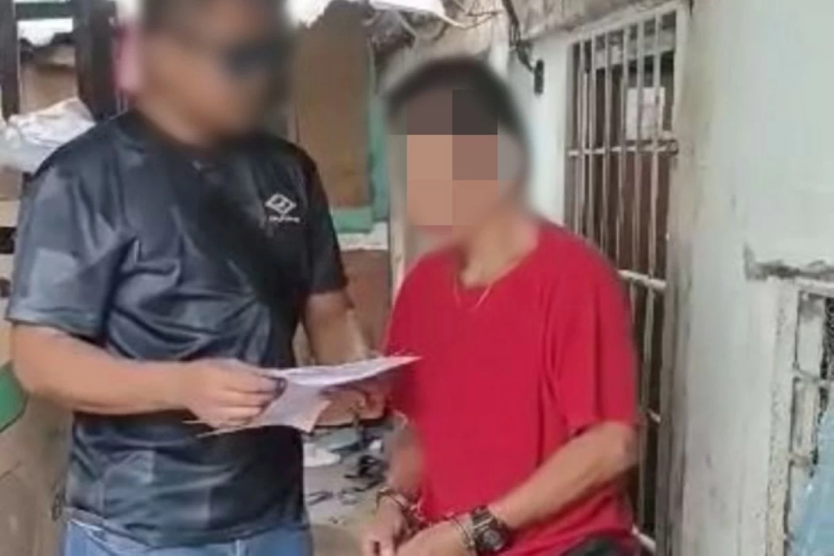 A police officer with the suspect (right) (Photo from Taguig police / SPD) 