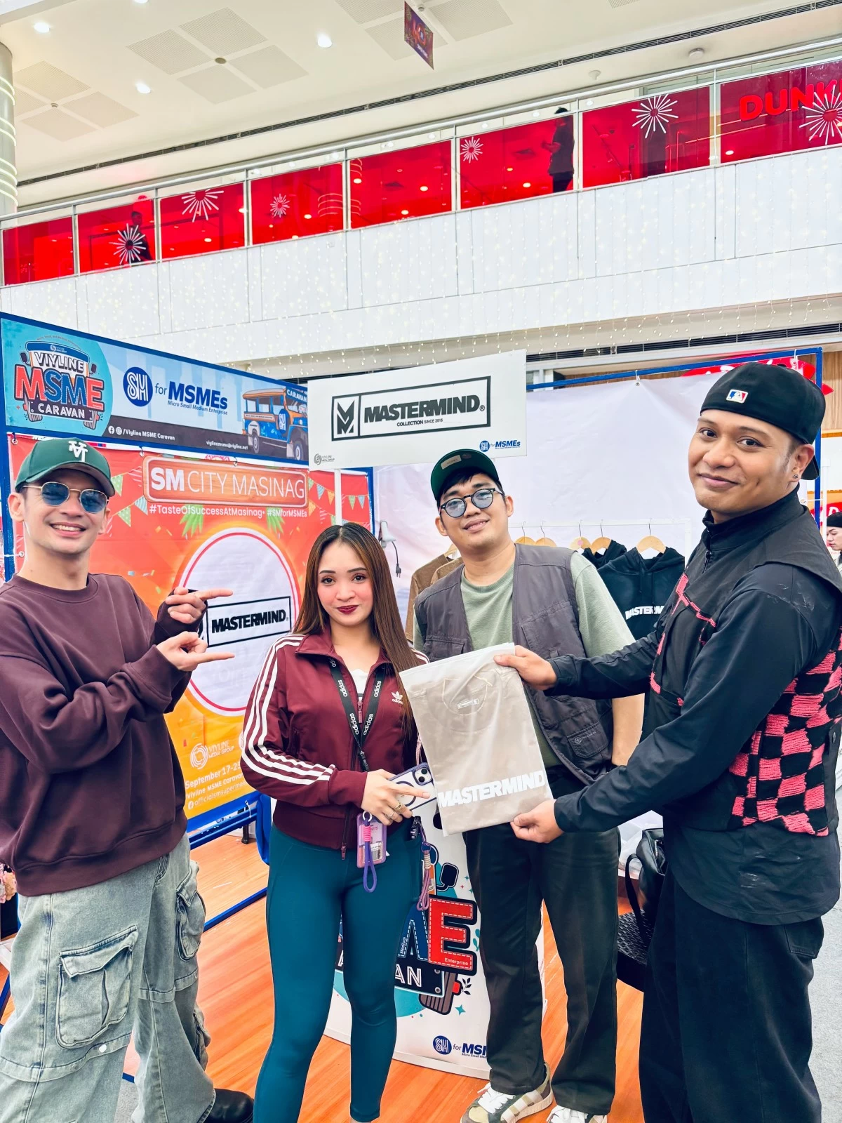Mastermind dance crew influencers Raymund Arago, David Inere, and Kristian Vienn Gonzalez pose with an excited fan as they give away exclusive merchandise during the VIYLine MSME Caravan at SM City Pampanga.
