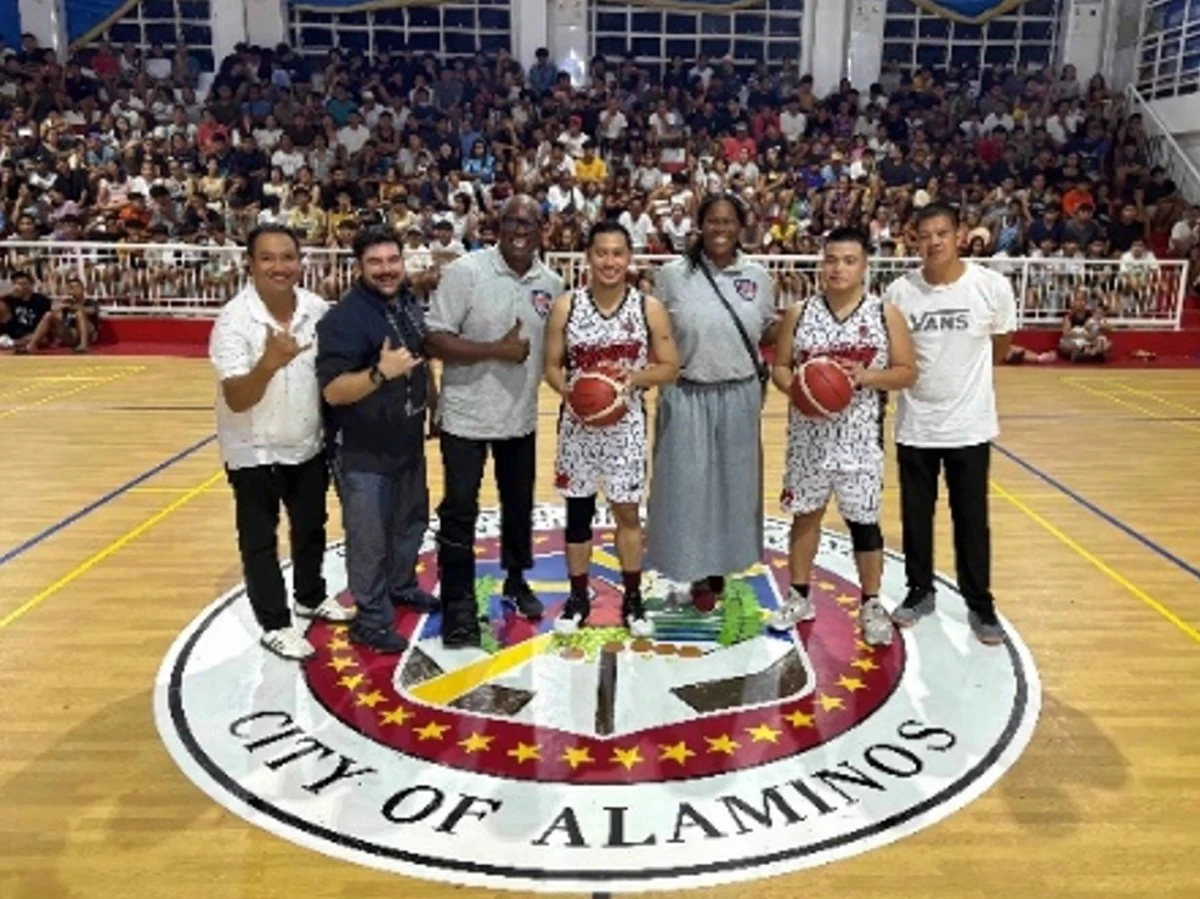 Alaminos City Youth and Sports Development Office Head Cloyd Peter Lalas, U.S. Embassy Deputy Director of Public Engagement George Mesthos, US Sports Envoy Sam Vincent, Alaminos City Mayor Arth Bryan Celeste, U.S. Sports Envoy Taj McWilliams-Franklin, and a player and coach of the Brgy. Magsaysay basketball team at an inter-barangay basketball tournament at the Alaminos City Sports Complex on September 29

