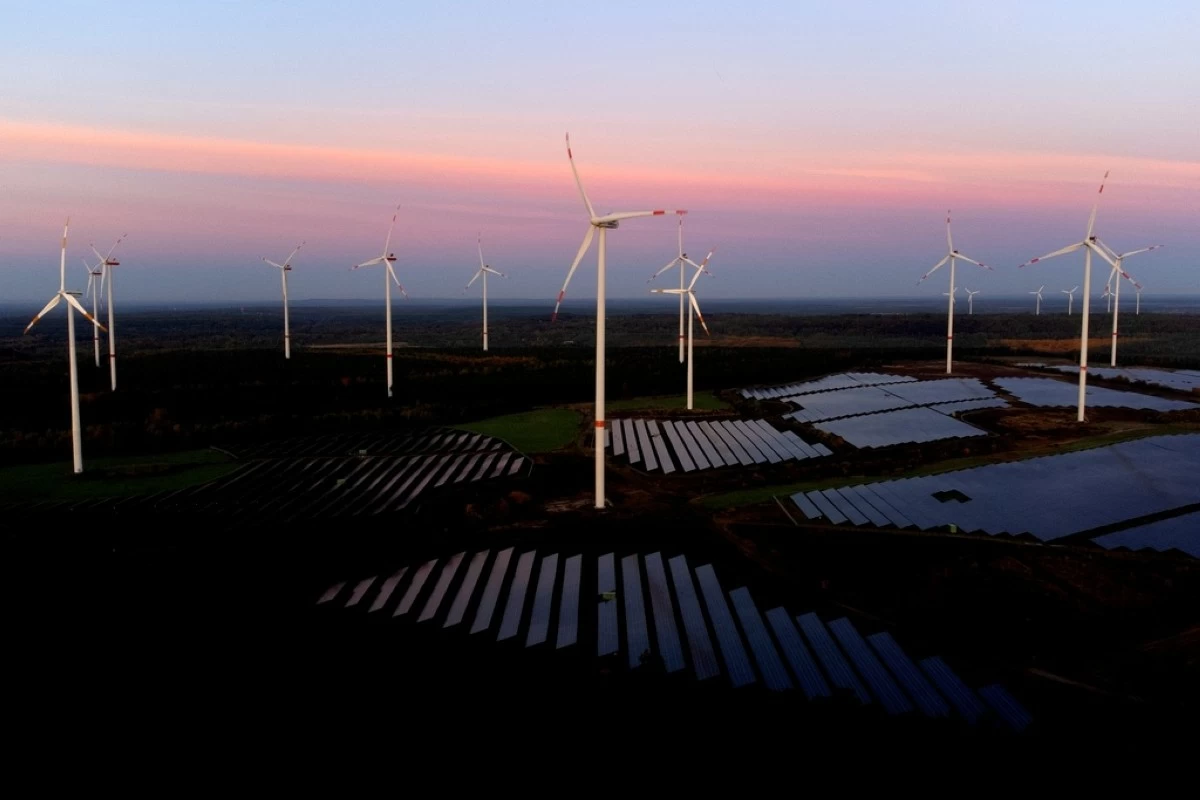 FILE - Wind turbines operate as the sun rises at the Klettwitz Nord solar energy park near Klettwitz, Germany, Oct. 16, 2024. (AP Photo/Matthias Schrader, File)