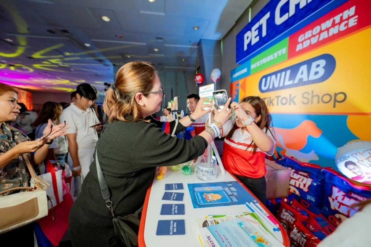 An affiliate enjoys participating in the activity, one of the many brand booths showcased for the event.