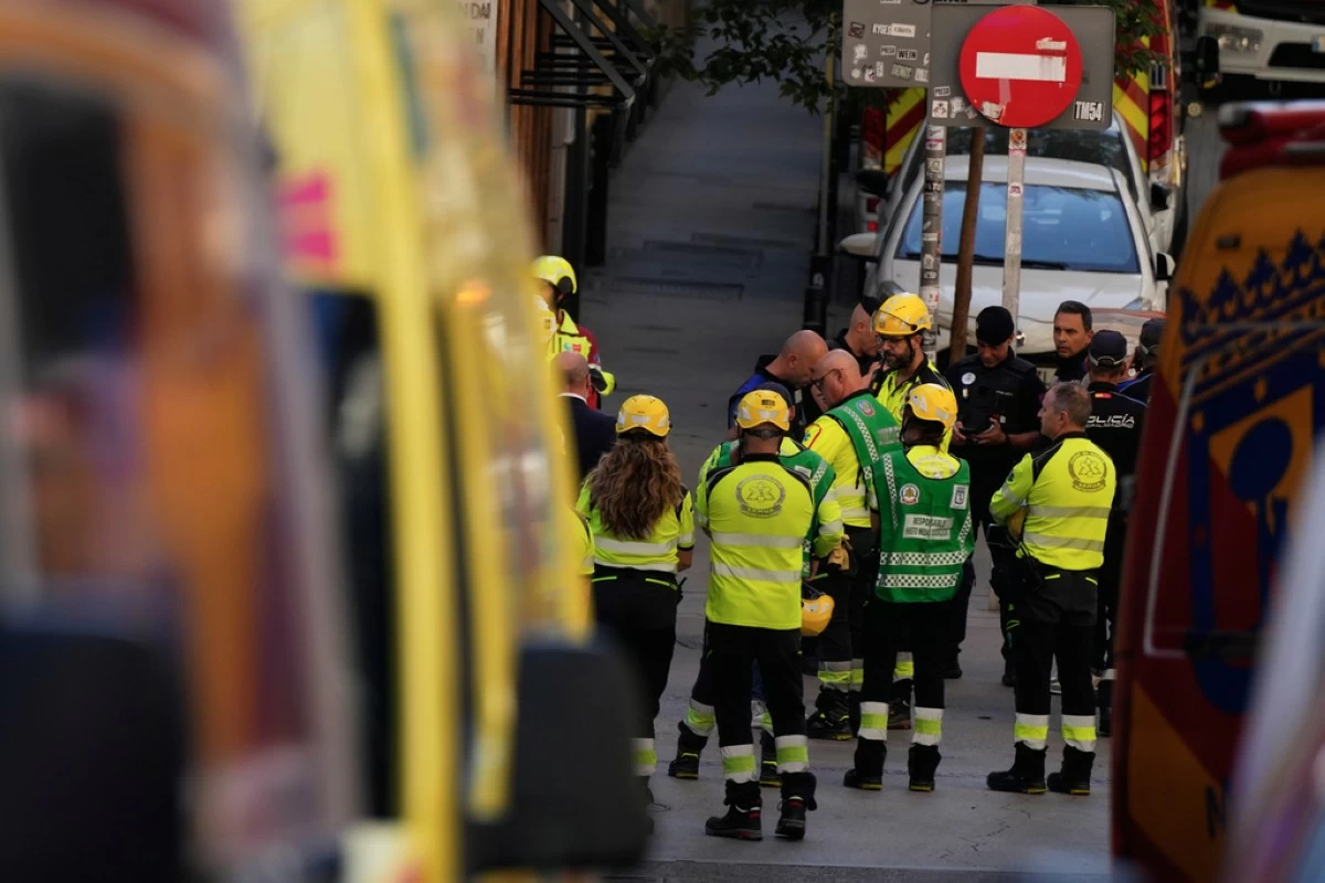 Emergency personnel respond to the scene of a building collapse in Madrid, Spain, on Tuesday, Oct. 7, 2025. (AP Photo/Manu Fernandez)