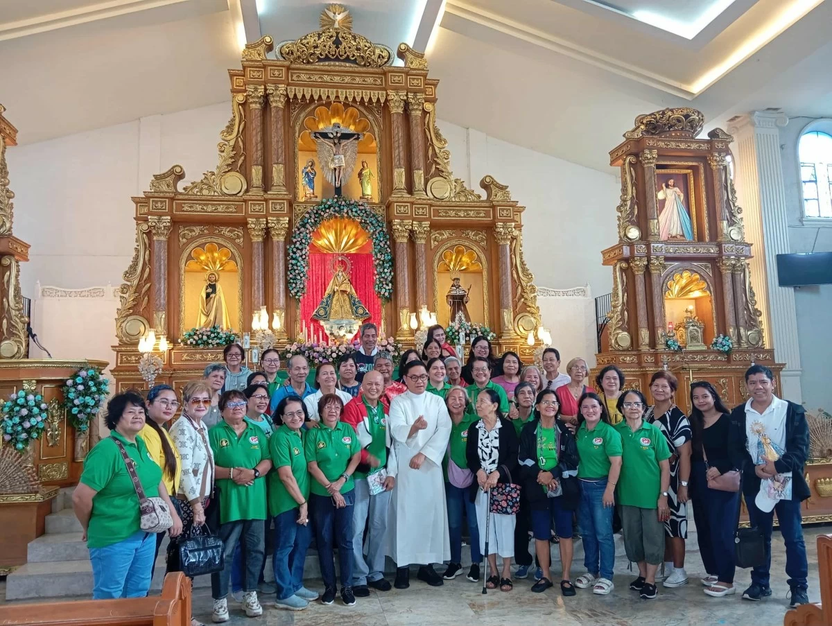 Fr. Reynante Tolentino poses with pilgrims from Parañaque City during a visit at the Diocesan Shrine and Parish of the Our Lady of the Holy Rosary