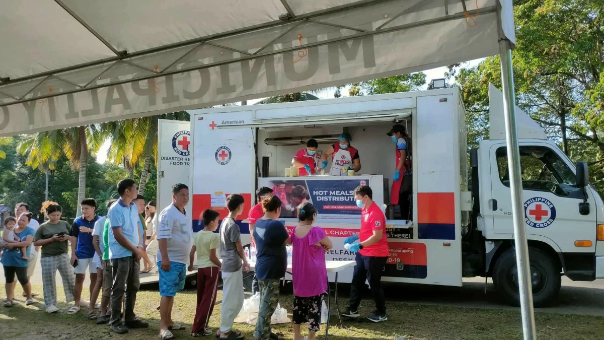 Philippine Red Cross volunteers distribute hot meals and bottled water to families affected by the recent “doublet earthquakes” in Davao Oriental. (Photo from PH Red Cross)