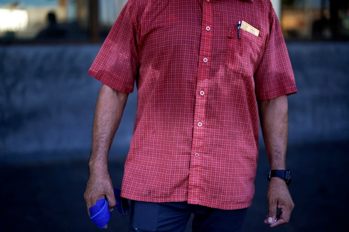FILE - Pablo Suarez's shirt is bathed in sweat before seven in the morning as he parks cars and provides security for a downtown cafe July 20, 2023, in Mexicali, Mexico. (AP Photo/Gregory Bull, File)