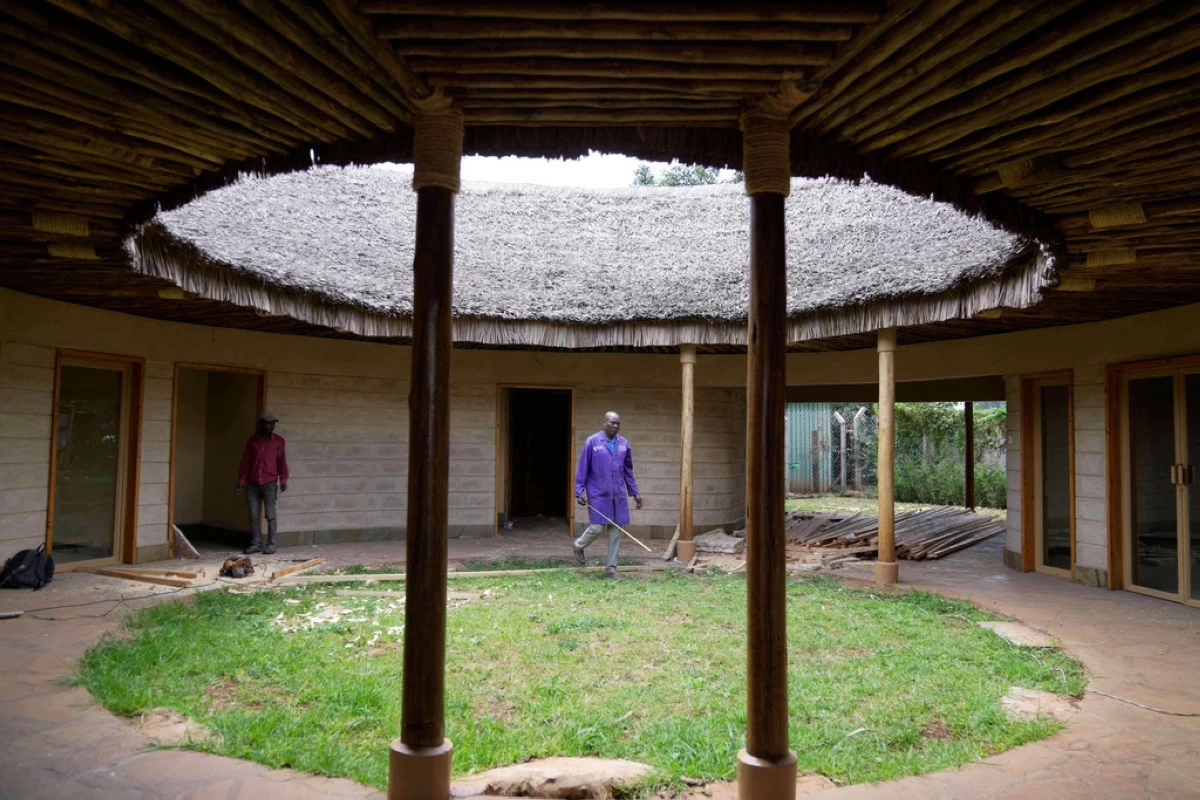 A contractor takes measurements inside a house under construction, inspecting wall and roof insulation made from agricultural waste and mushroom mycelium in Nairobi, Kenya, Friday, Sept. 12, 2025. (AP Photo/Brian Inganga)