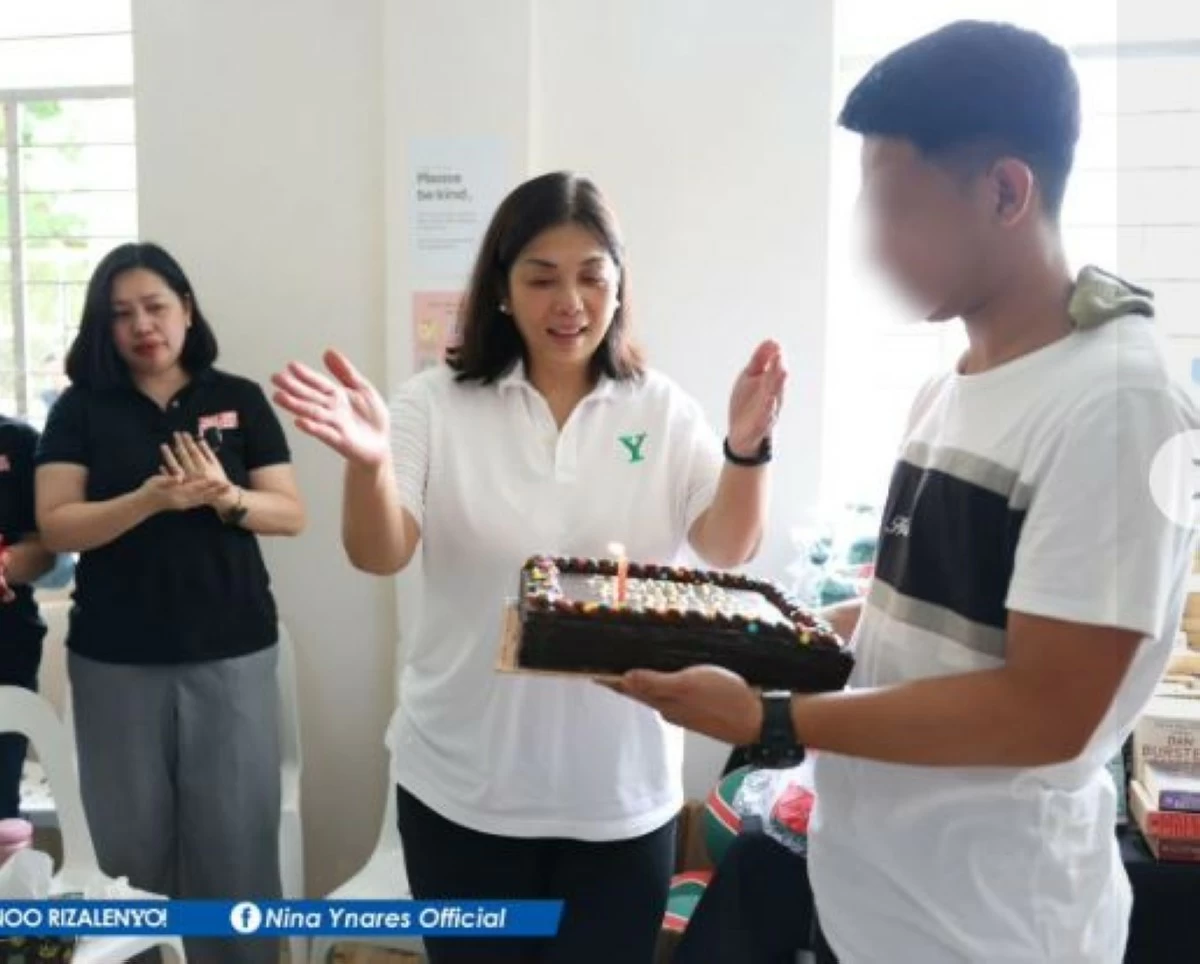 A teenager, a child in-conflict-with the law holds a cake with a lighted candle for Gov. Ynares (Photo from Rizal Provincial Government)
