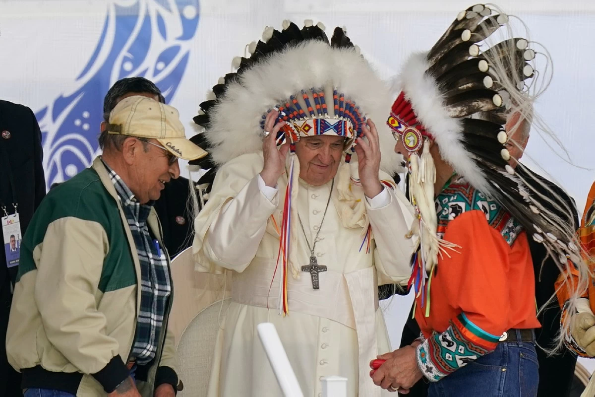 FILE - Pope Francis dons a headdress during a visit with Indigenous peoples at Maskwaci, the former Ermineskin Residential School, Monday, July 25, 2022, in Maskwacis, Alberta. (AP Photo/Eric Gay, File)
