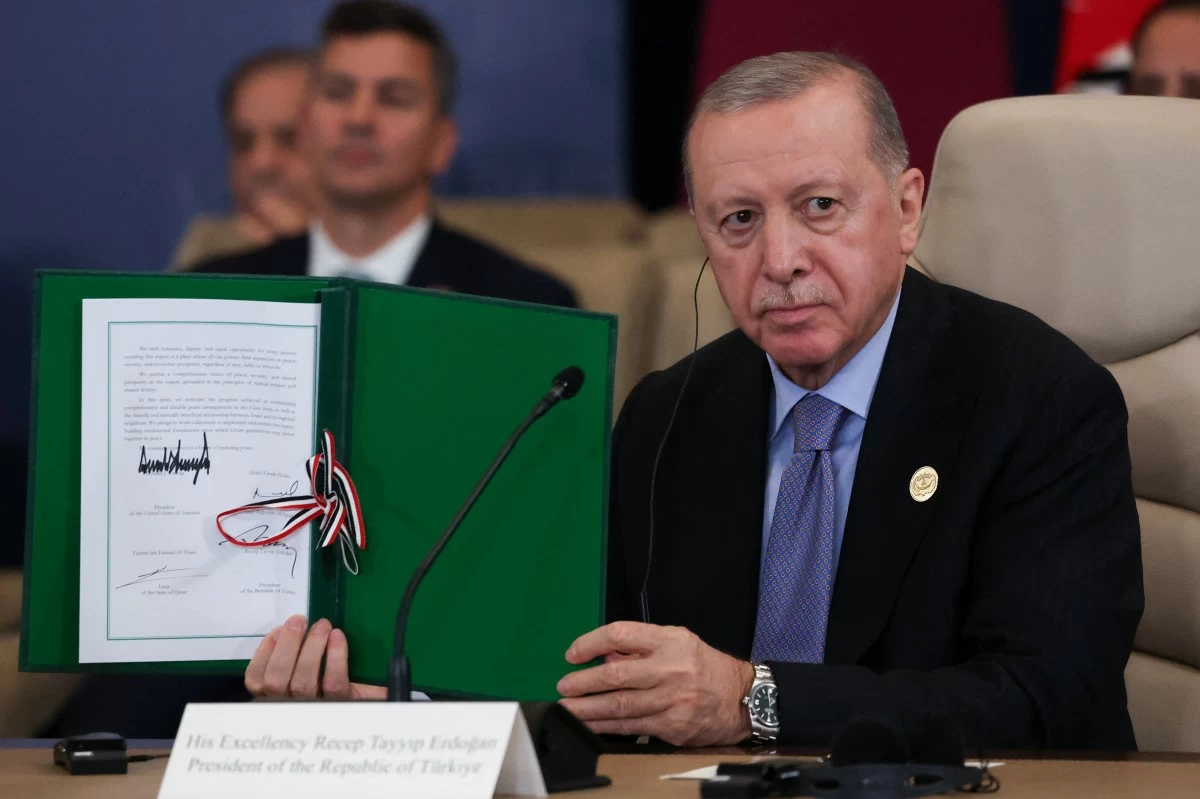 Turkey's President Recep Tayyip Erdogan holds a signed document during a summit to support ending the more than two-year Israel-Hamas war in Gaza after a breakthrough ceasefire deal, Monday, Oct. 13, 2025, in Sharm El Sheikh, Egypt. (Suzanne Plunkett/Pool via AP)