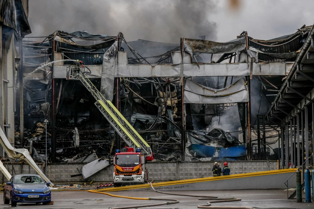 A firefighter works to extinguish a fire at a warehouse following a Russian attack, Saturday, Oct. 25, 2025, in Kyiv, Ukraine. (AP Photo/Julia Demaree Nikhinson)