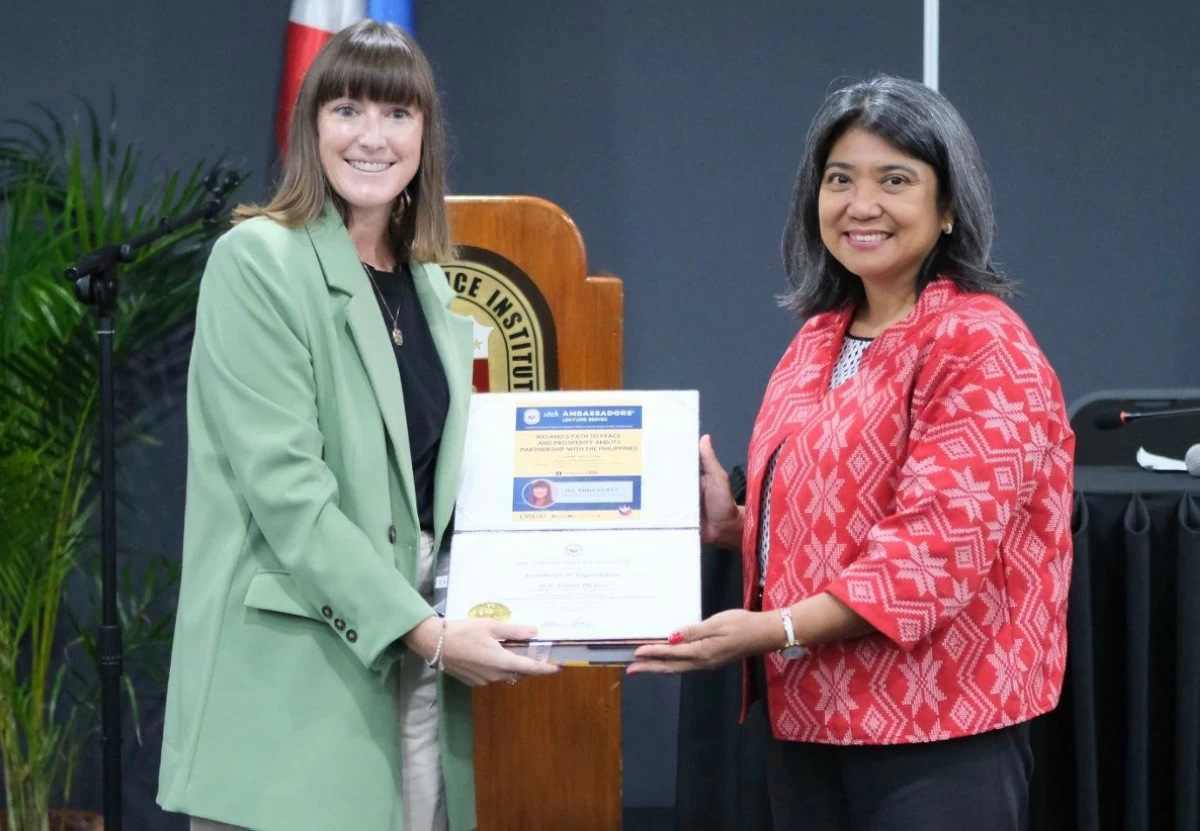 FSI executive director Indhira C. Bañares presents a token of appreciation to Ambassador Emma Hickey.
