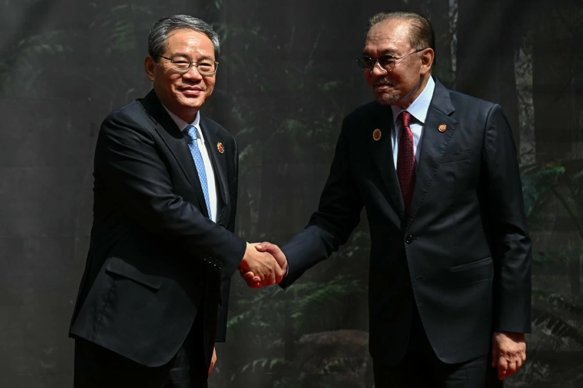 China's Premier Li Qiang, left, shakes hands with Malaysia's Prime Minister Anwar Ibrahim as he arrives at the Kuala Lumpur Convention Centre to attend the 47th Association of Southeast Asian Nations (ASEAN) summit in Kuala Lumpur, Malaysia, Monday, Oct. 27, 2025. (Lillian Suwanrumpha/Pool Photo via AP)