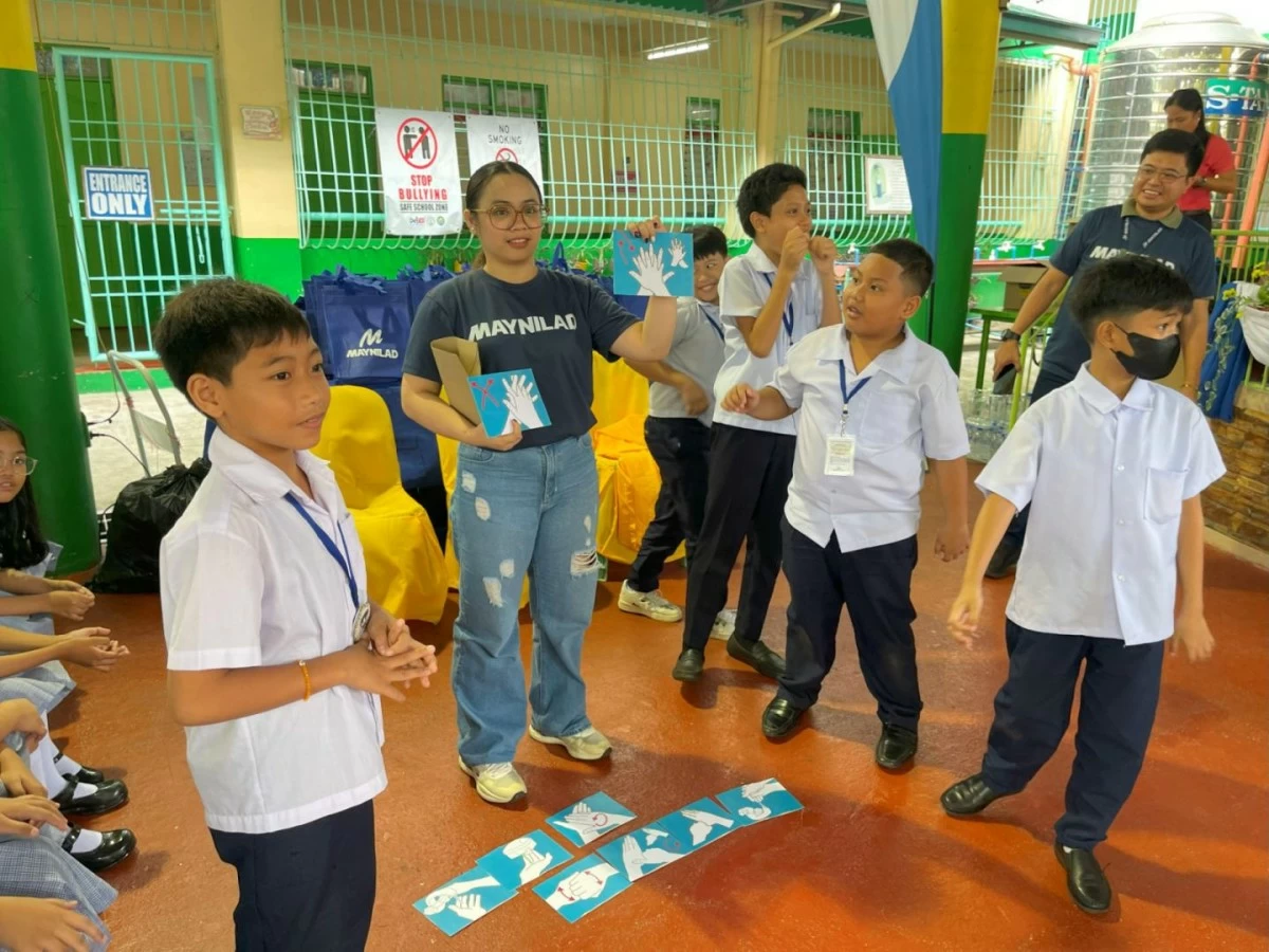Students of Pamplona Elementary School Unit 1 take part in a handwashing game, which is among the teaching strategies that Maynilad volunteers use in its WASH trainings. 
