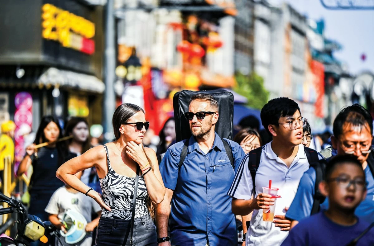 Chinese and international tourists explore Dashilan commercial zone of Qianmen Street in Beijing, Oct. 2, 2025. (Photo/Zhu Zhenqiang)