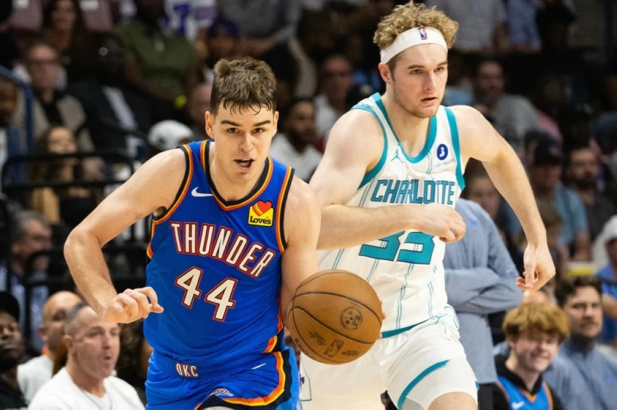 Oklahoma City Thunder guard Nikola Topic, left, drives the ball upcourt against Charlotte Hornets forward Liam McNeeley, right, during the second half of an NBA basketball preseason game in North Charleston, S.C., Sunday, Oct. 5, 2025. (AP Photo/Mic Smith)

