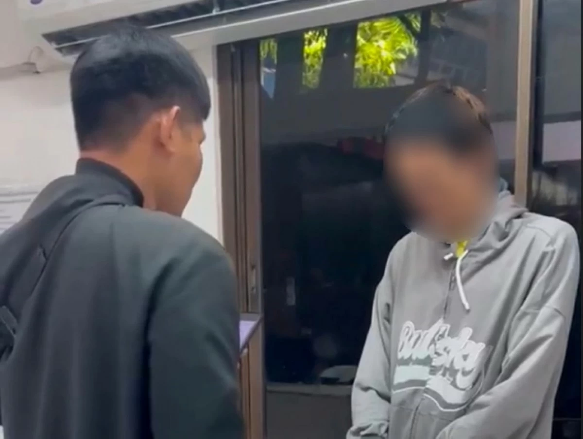 A Taguig police officer with the suspect (right) (Photo from Taguig police / SPD) 