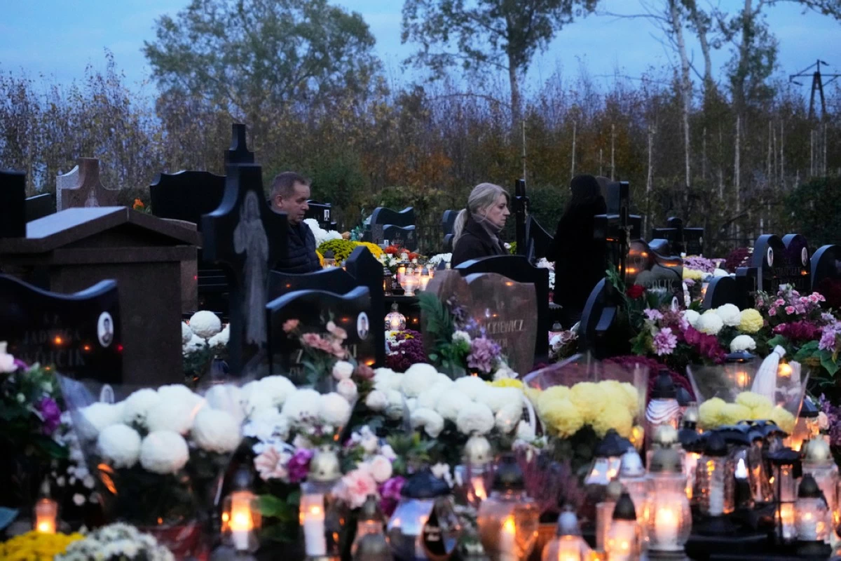 People observe All Saints' Day, a time for reflecting on those who have died, in Kroczewo near Warsaw, Poland, Saturday, Nov. 1, 2025. (AP Photo/Czarek Sokolowski)
