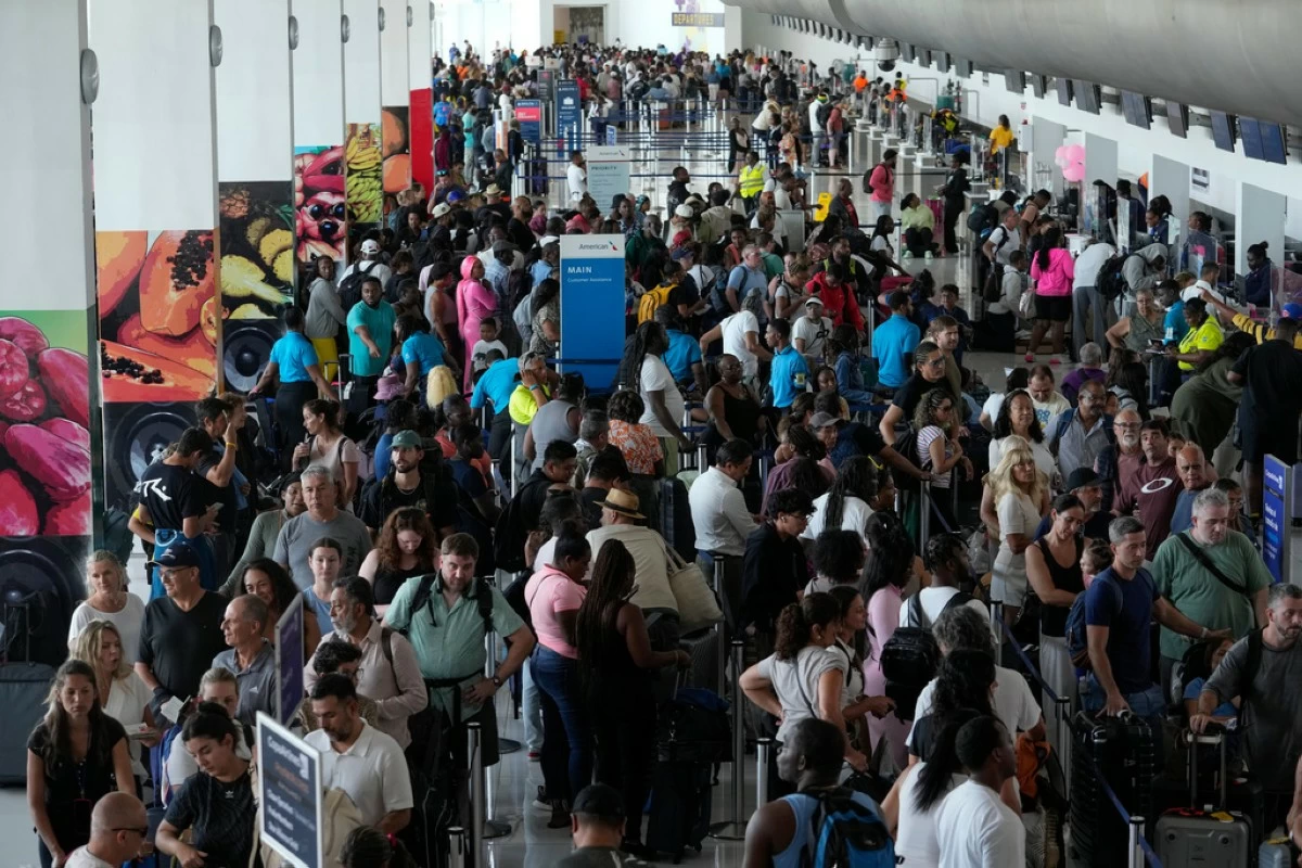 Passengers check in at the Norman Manley International Airport in Kingston, Jamaica, Saturday, Nov. 1, 2025, in the aftermath of Hurricane Melissa. (AP Photo/Matias Delacroix)