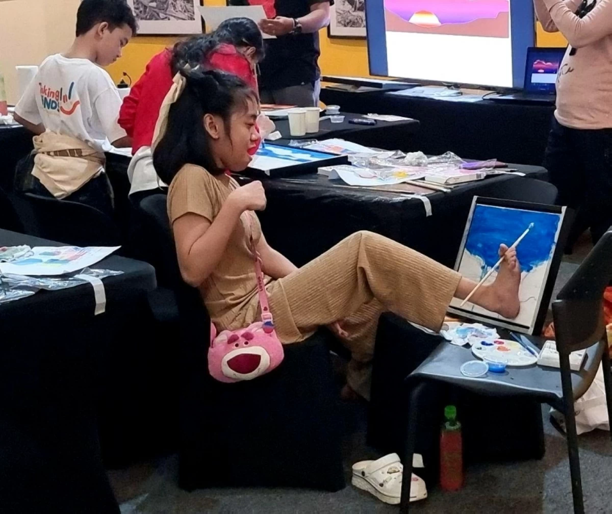 Outstanding artist Ryza Yohanne Reyes paints using her foot (Photo from FSL4IPH)