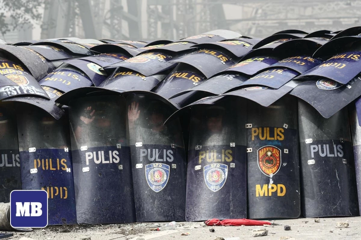 Riot police officers stand shoulder to shoulder behind their shields to form a defensive wall during an anti-corruption protest at Ayala Bridge in Manila on Sept. 21, 2025. (John Louie Abrina / MANILA BULLETIN)