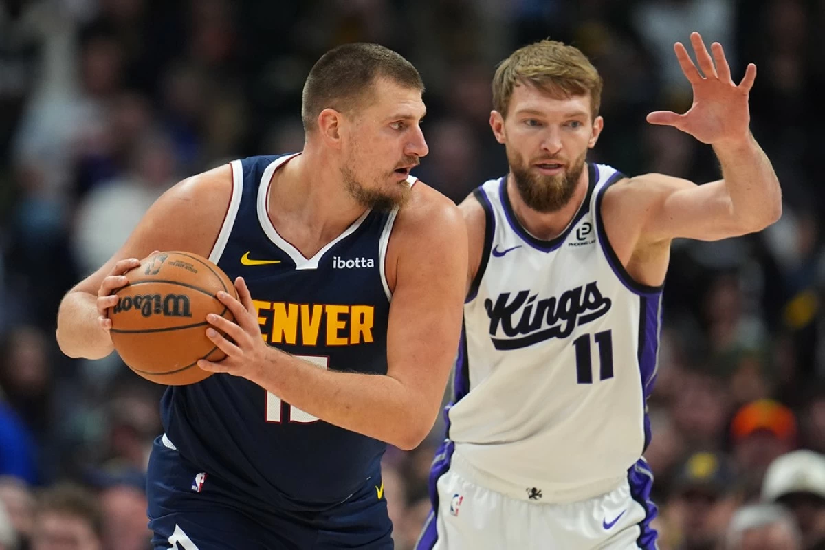 Denver Nuggets center Nikola Jokic, left, looks to pass the ball as Sacramento Kings forward Domantas Sabonis defends in the first half of an NBA basketball game Monday, Nov. 3, 2025, in Denver. (AP Photo/David Zalubowski)