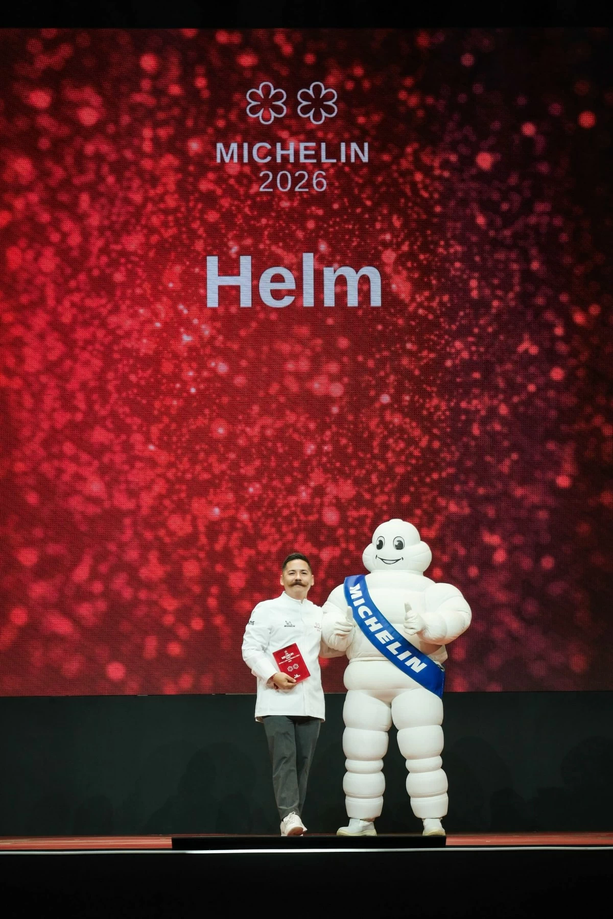 A DOUBLE STAR MOMENT Chef Josh Boutwood of Helm celebrates with the Michelin Man after earning two stars at the Michelin Guide Philippines 2026 awards night