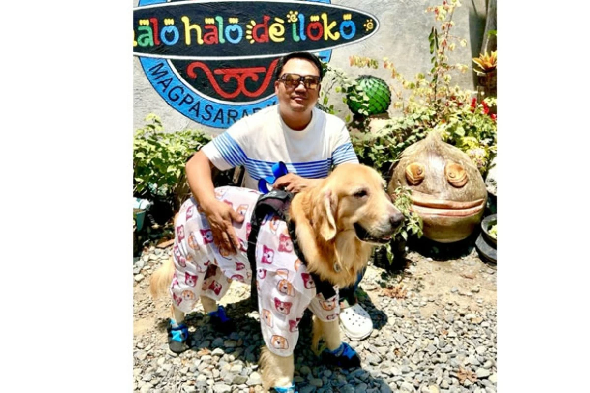 Chef Xave poses in front of his restaurant with his dog, a familiar face to regular customers of Halo-Halo de Iloko. 