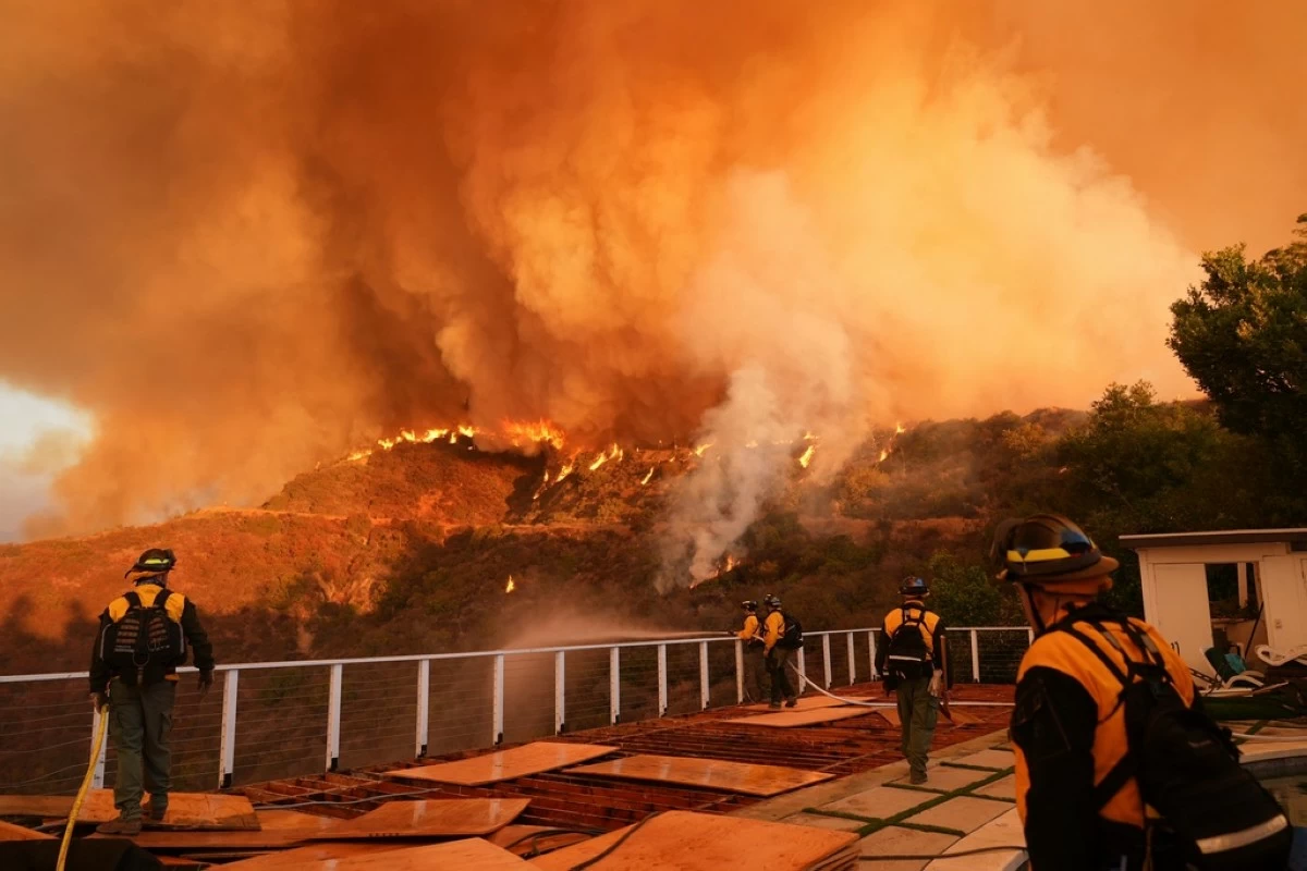 FILE - Fire crews monitor the Palisades Fire in Mandeville Canyon on Jan. 11, 2025, in Los Angeles. (AP Photo/Jae C. Hong, File)