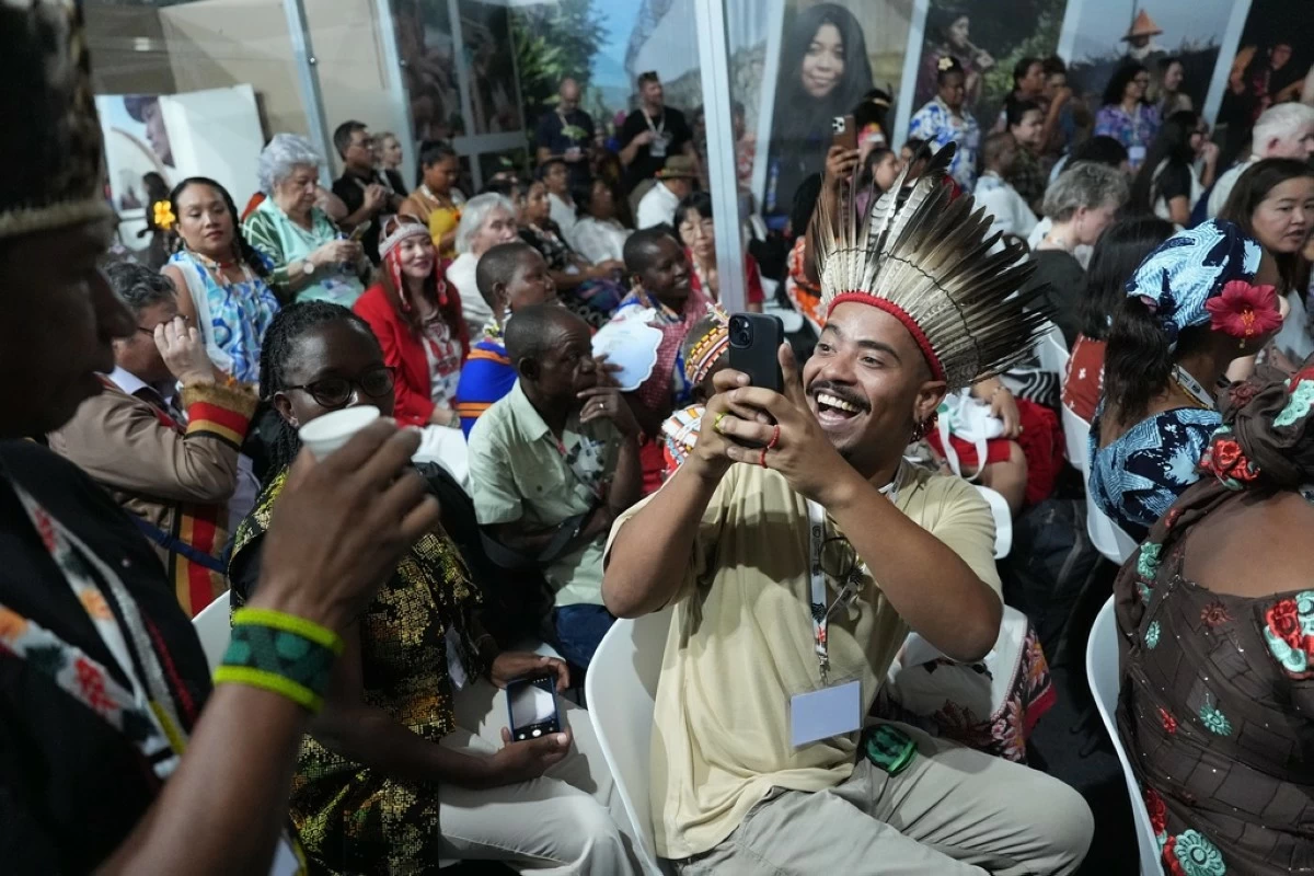 Djalma Ramalho Goncalves, holds their phone at the opening of the Indigenous Peoples Pavilion at the COP30 U.N. Climate Summit, Monday, Nov. 10, 2025, in Belem, Brazil. (AP Photo/Joshua A. Bickel)