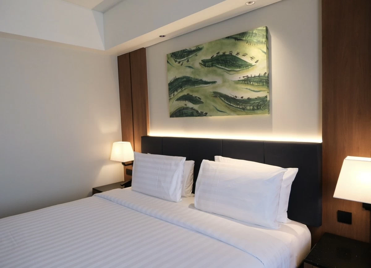 A deluxe room decorated with a painting by Goldie Siglos