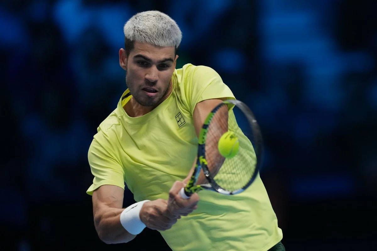 Spain's Carlos Alcaraz returns the ball to Italy's Lorenzo Musetti during their singles tennis match of the ATP World Tour Finals, in Turin, Italy, Thursday, Nov. 13, 2025. (AP Photo/Antonio Calanni)