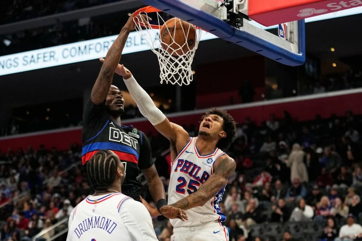 Detroit Pistons guard Javonte Green, top left, dunks the ball against Philadelphia 76ers center Andre Drummond, bottom, and forward Dominick Barlow during the second half of an NBA Cup basketball game Friday, Nov. 14, 2025, in Detroit. (AP Photo/Ryan Sun)