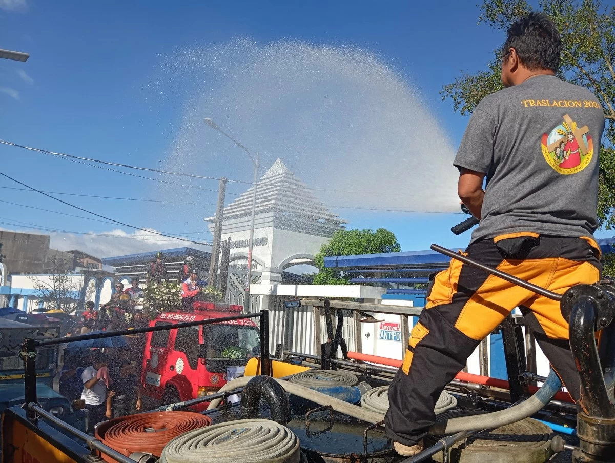 A fireman trains a water hose in salute on the firetruck that bears the casket of Magpusao. (Photo by Nel Andrade/Manila Bulletin)
