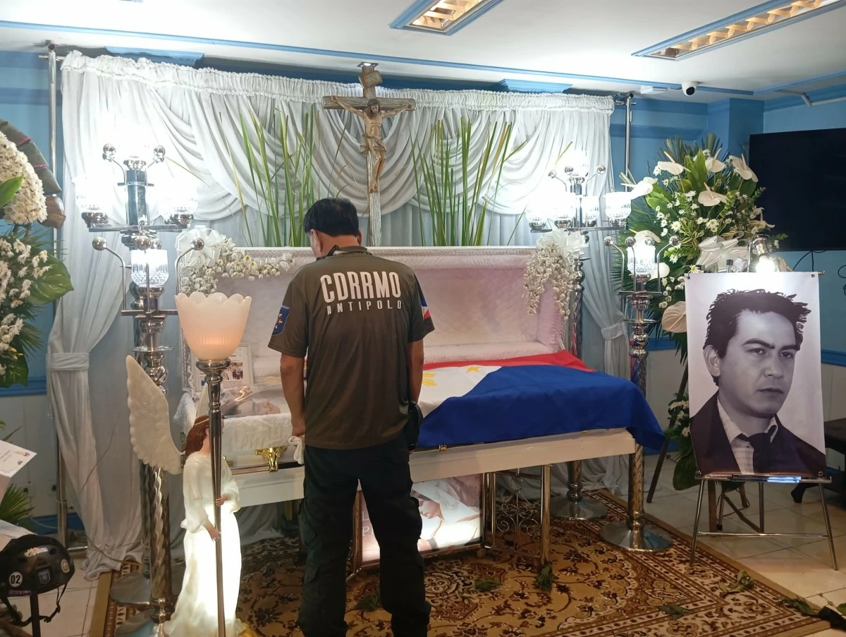 A co-rescuer of Magpusao prays in front of the coffin bearing Magpusao, a member of Barangay San Roque Fire and Rescue team (Photo by Nel Andrade/Manila Bulletin)