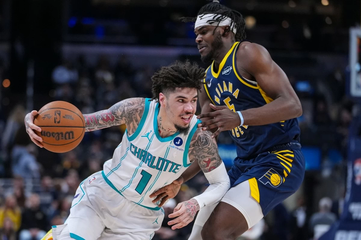 Charlotte Hornets guard Lamelo Ball (1) drives on Indiana Pacers forward Jarace Walker (5) during the first half of an NBA basketball game in Indianapolis, Wednesday, Nov. 19, 2025. (AP Photo/Michael Conroy)