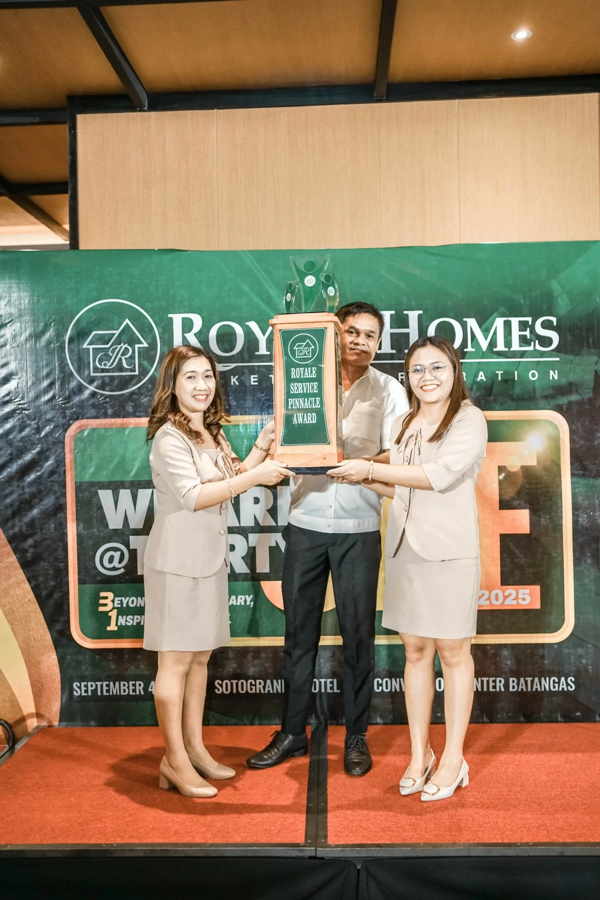 Employee of the Year awardees proudly showing off their stunning trophy. Awardees include Karen Cua (Supervisory Category), Benjamin Tating Jr. (Technical Category) and Roselyn Punto (Staff Category).
