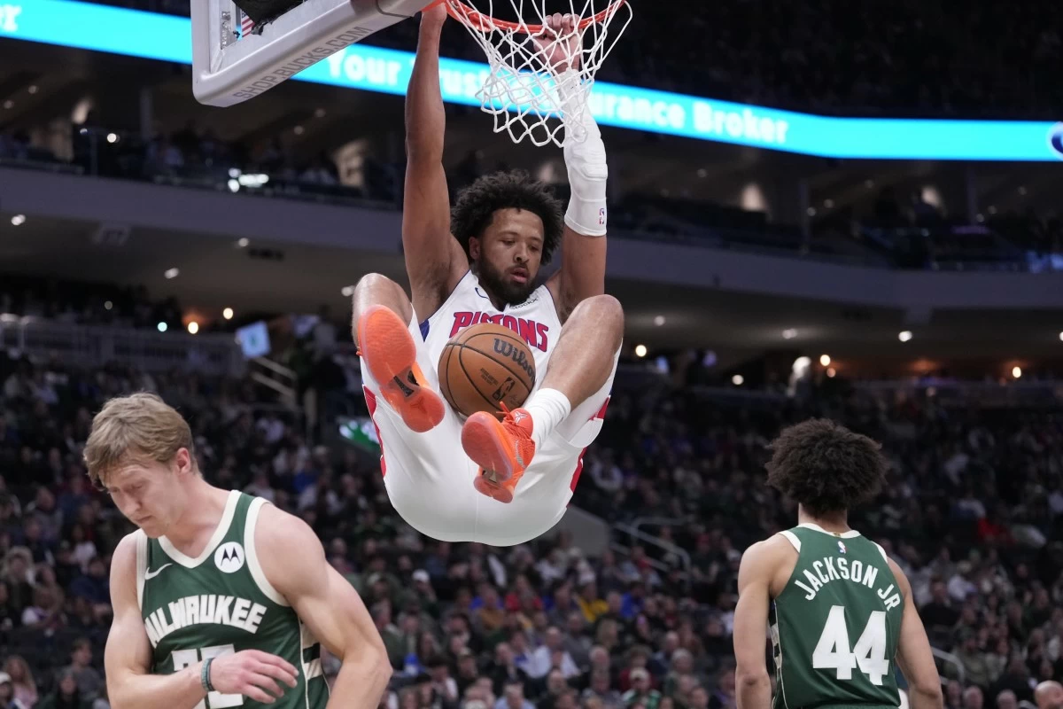 Detroit Pistons' Cade Cunningham dunks over Milwaukee Bucks' AJ Green and Andre Jackson Jr. during the first half of an NBA basketball game Saturday, Nov. 22, 2025, in Milwaukee. (AP Photo/Morry Gash)