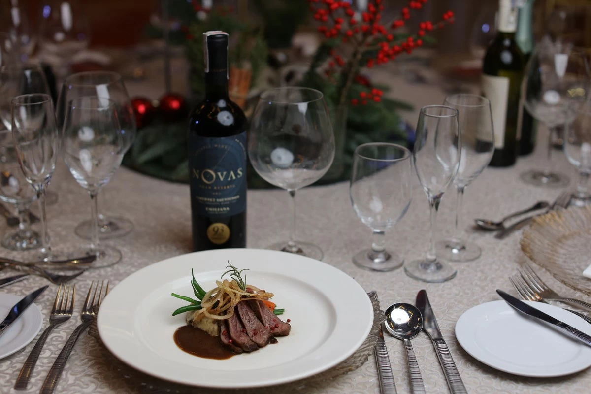 23-day dry-aged grilled New York Strip Steak served with glazed carrots, haricot vert, potato purée with mushrooms, crispy onions, and port sauce, paired with Emiliana Organic Novas Gran Reserva Cabernet Sauvignon from Chile.
