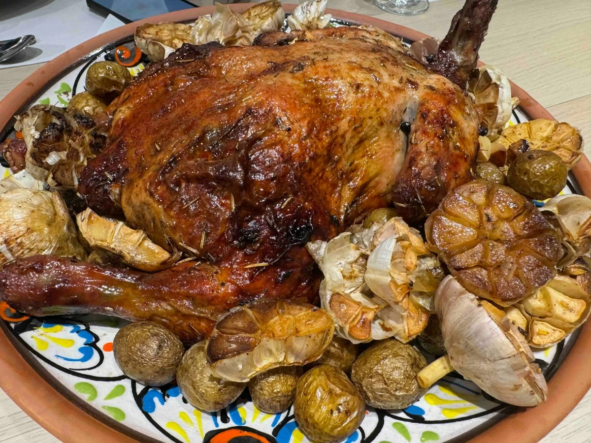 SUNDAY ROAST Golden roast chicken with whole garlic and baby potatoes adds a hearty, familiar note to the evening’s spread.