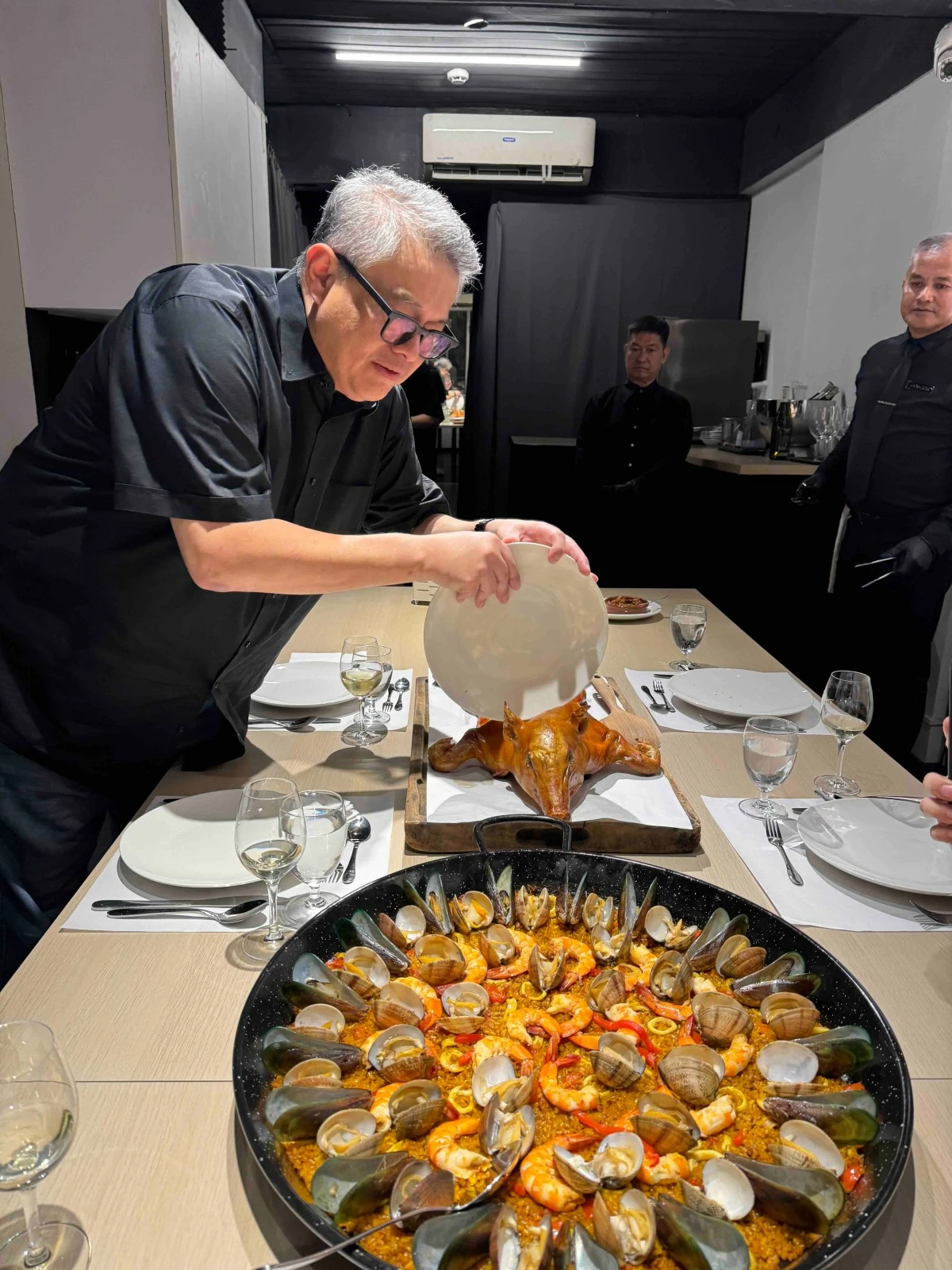 CRISPY MOMENT Tinee de Guzman breaks open his signature cochinillo with a single, confident strike, revealing the crisp skin and tender meat that anchor every gathering at his Marikina table.