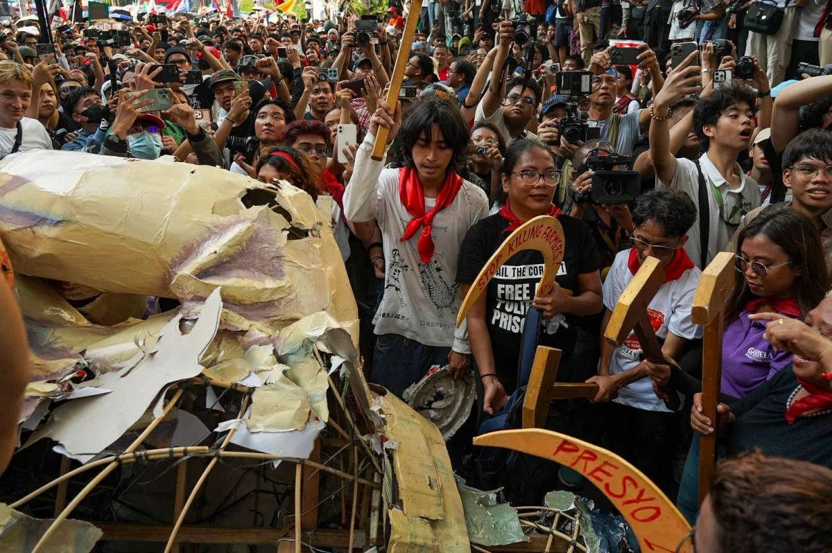 Members of multisectoral groups tear apart an effigy of President Ferdinand Marcos Jr. and Vice President Sara Duterte during the anti-corruption protest in Recto, Manila, after being blocked from proceeding to Mendiola.