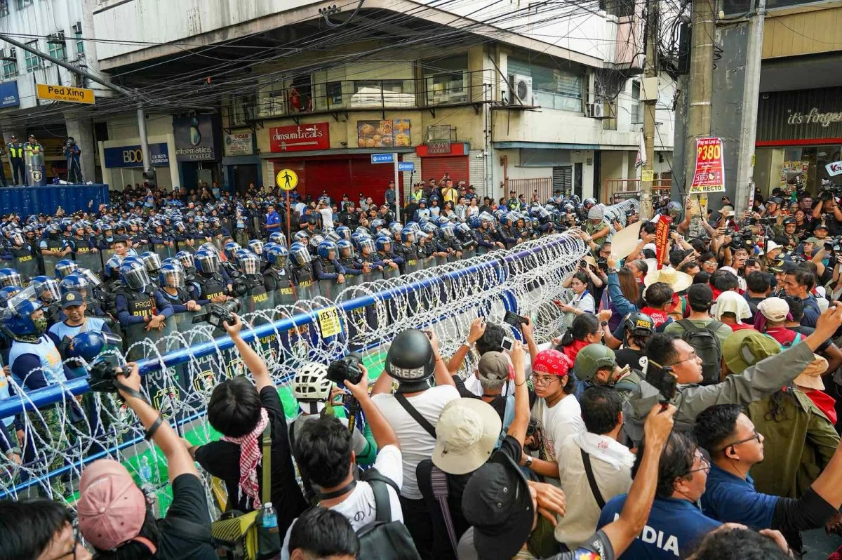 Protesters sing “Bayan Ko” in front of a police barricade after their anti-corruption march was halted at the corner of Recto Avenue and San Sebastian Street on Bonifacio Day, November 30.