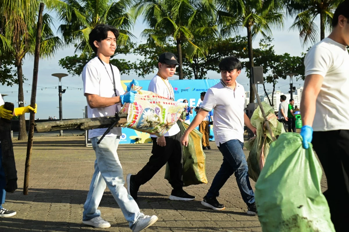 Young volunteers step up for cleaner coastlines, carrying sacks of collected waste during SM Cares’ coastal cleanup—building a #SMWasteFreeFuture together.