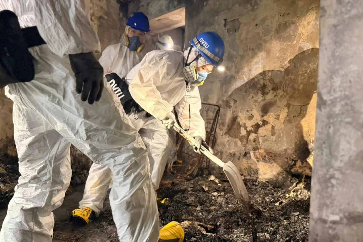 In this photo released by Hong Kong Police Public Relations Branch, members of the Disaster Victim Identification Unit work in an apartment in the aftermath of a deadly Wednesday fire at Wang Fuk Court, a residential estate in the Tai Po district of Hong Kong's New Territories Sunday, Nov. 30, 2025. (Hong Kong Police Public Relations Branch via AP)