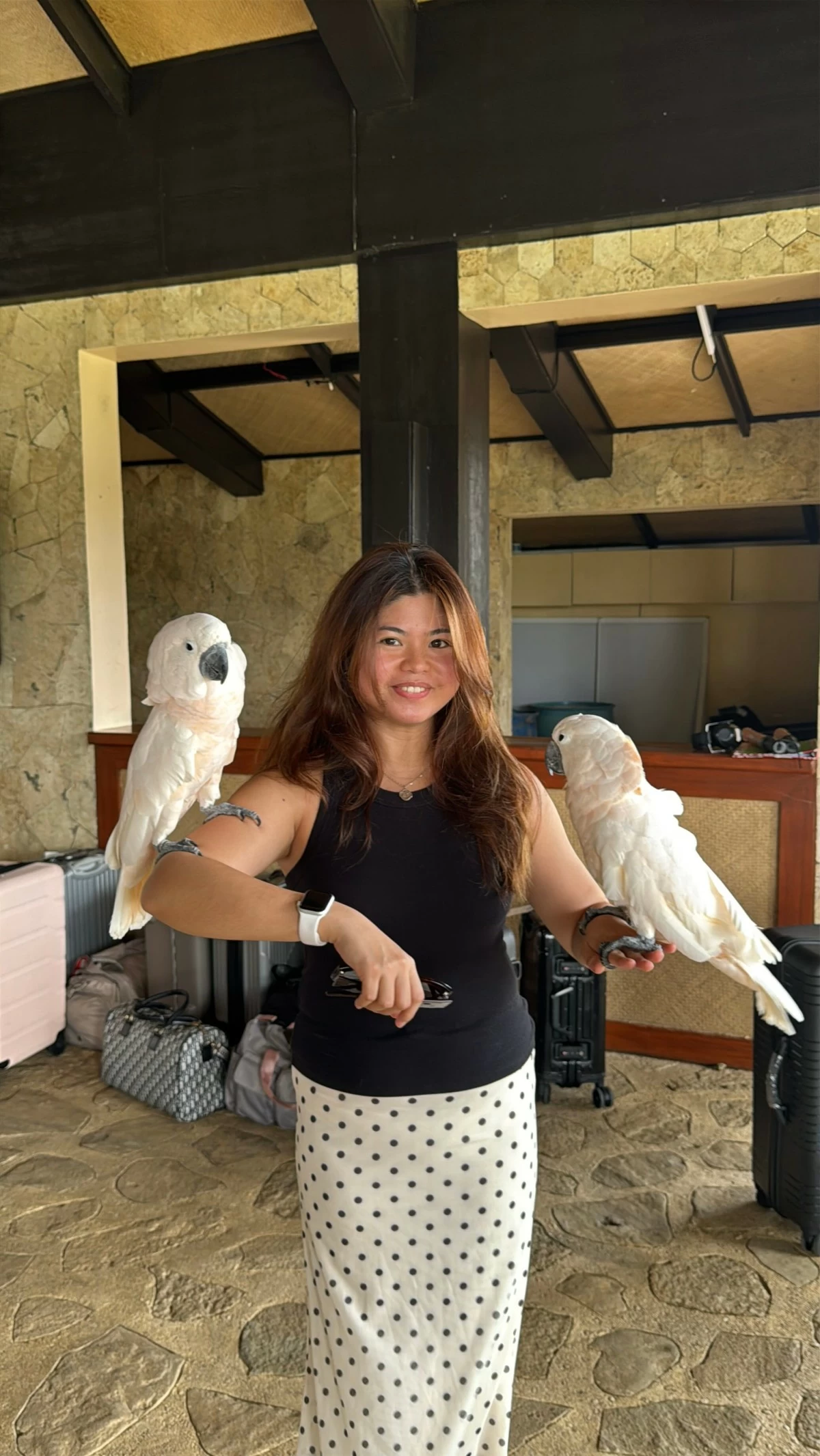 ISLAND WELCOME Balesin guest Nicole Ku holds the two white birds that greet arriving guests on Balesin Island.